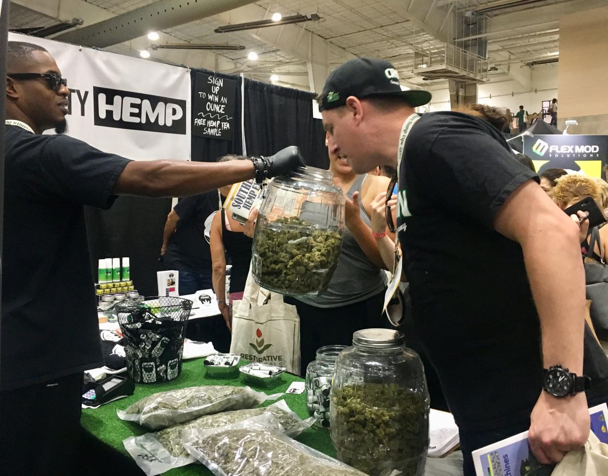 An attendee at the Southern Hemp Expo smells raw hemp flower sold by one of its vendors on Sept. 6, 2019.