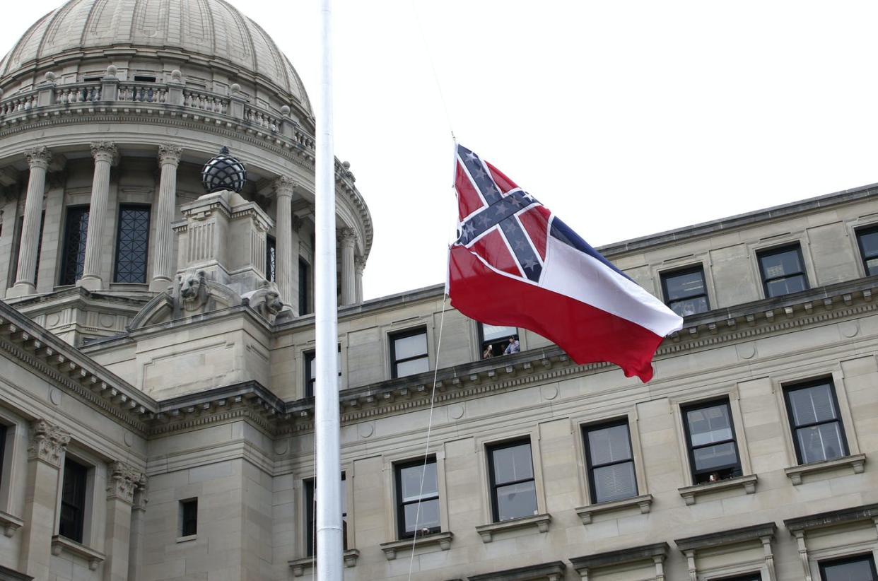 <span class="caption">The Mississippi state flag, with a representation of the Confederate battle flag, is raised one last time over the state Capitol building on July 1, 2020.</span> <span class="attribution"><a class="link " href="http://www.apimages.com/metadata/Index/Racial-Injustice-Confederate-Flag-Mississippi/87de408c0f404e8bb390b32c84d63636/49/0" rel="nofollow noopener" target="_blank" data-ylk="slk:AP Photo/Rogelio V. Solis;elm:context_link;itc:0;sec:content-canvas">AP Photo/Rogelio V. Solis</a></span>
