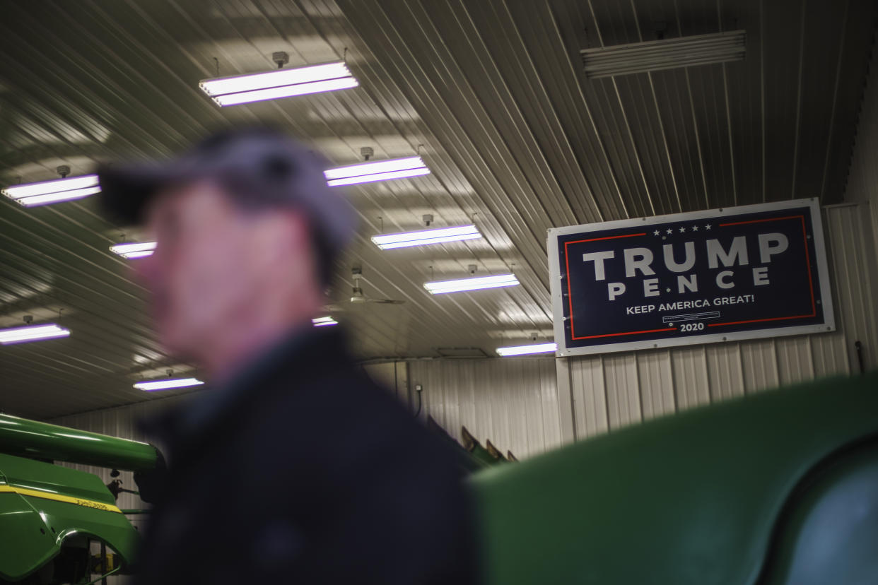 Al Saunders stands beneath a Trump campaign sign in his farm's tool shed in Benson, Minn., Wednesday, Dec. 1, 2021. Trump's cries that he loved America resonated in an area where new approaches to teaching U.S. history, with an increased focus on race, were confounding. So in a county where Obama won with 55% of the vote in 2008, Trump won with 64% percent in 2020. "We've seen a shift here in Swift County," said Saunders. "But you won't see that in the newspaper." (AP Photo/David Goldman)
