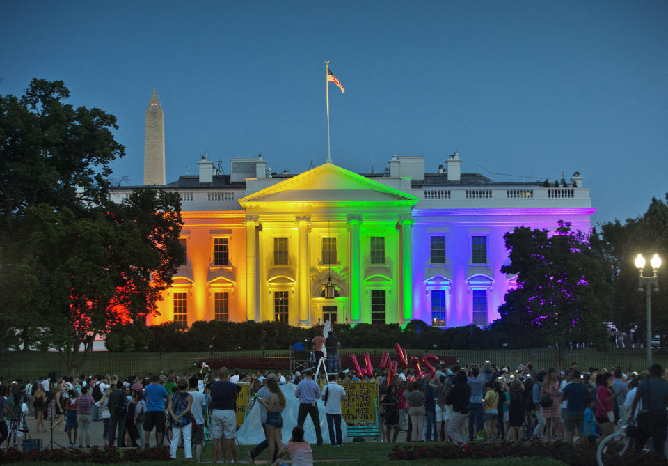 FILE - People gather in Washington's Lafayette Park to see the White House illuminated with rainbow colors to mark the U.S. Supreme Court's ruling to legalize same-sex marriage, June 26, 2015. President Joe Biden plans to sign legislation this coming week that will protect gay unions even if the Supreme Court revisits its ruling supporting a nationwide right of same-sex couples to marry. It's the latest part of Biden's legacy on gay rights, which includes his unexpected endorsement of marriage equality on national television a decade ago when he was vice president. (AP Photo/Pablo Martinez Monsivais, File)