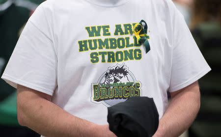A man wears a Humboldt Broncos shirt during a vigil at the Elgar Petersen Arena, home of the Humboldt Broncos, to honour the victims of a fatal bus accident in Humboldt, Saskatchewan, Canada April 8, 2018. Jonathan Hayward/Pool via REUTERS