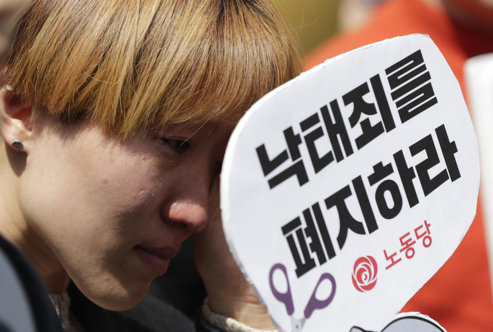 A woman wipes tears during a rally demanding the abolition of abortion law outside of the Constitutional Court in Seoul, South Korea, Thursday, April 11, 2019. South Korea's Constitutional Court has ruled that the country's decades-long ban on abortions is incompatible with the constitution, setting up a likely easing of restrictions. (AP Photo/Lee Jin-man)