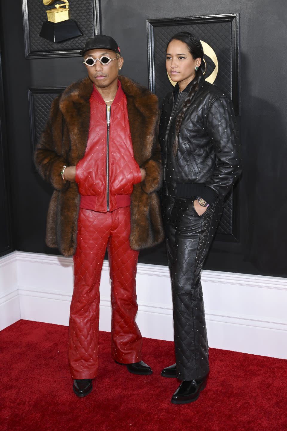 <p>Pharrell Williams managed to channel both Margot and Richie Tenenbaum with his Grammys look: a quilted red leather set embellished with silver pearls worn under a faux-fur jacket. Helen Lasichanh matched in a black set sans coat.</p>