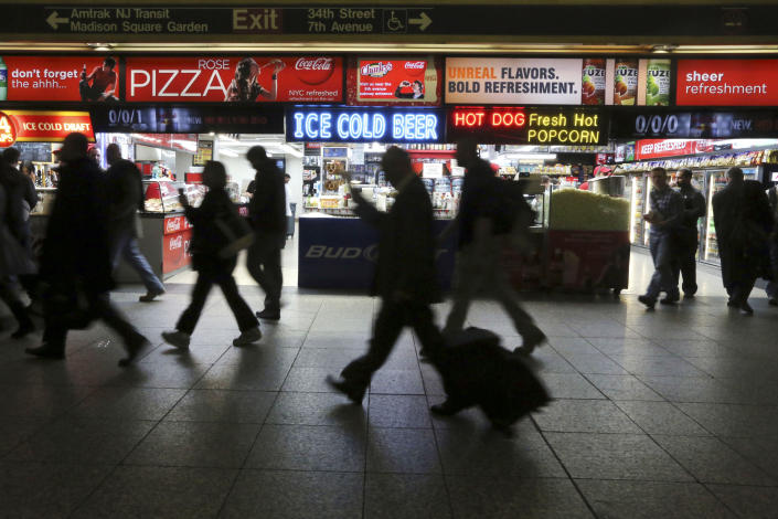 This May 9, 2013 photo shows evening rush hour commuters making their way past the food concessions on an underground concourse inside New York's Penn Station. The busiest passenger train station in the United States, gateway to the biggest city in the nation, is a 1960s-era, utilitarian labyrinth built in what is essentially the basement of Madison Square Garden. Two decades after ambitious plans were unveiled to improve Penn Station while expanding it into the massive Beaux Arts post office building across the street, there are few visible signs of change. (AP Photo/Mary Altaffer)