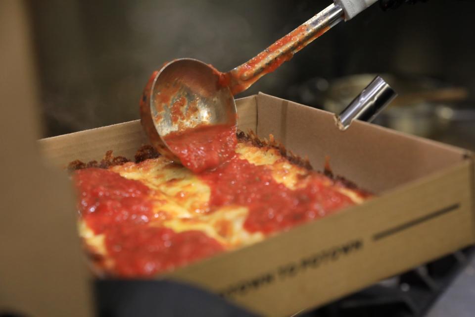 Hudson & Packard Detroit Pizza chef and owner, Charlie Webb sauces up a pizza in the City of Poughkeepsie on April 7, 2022. 