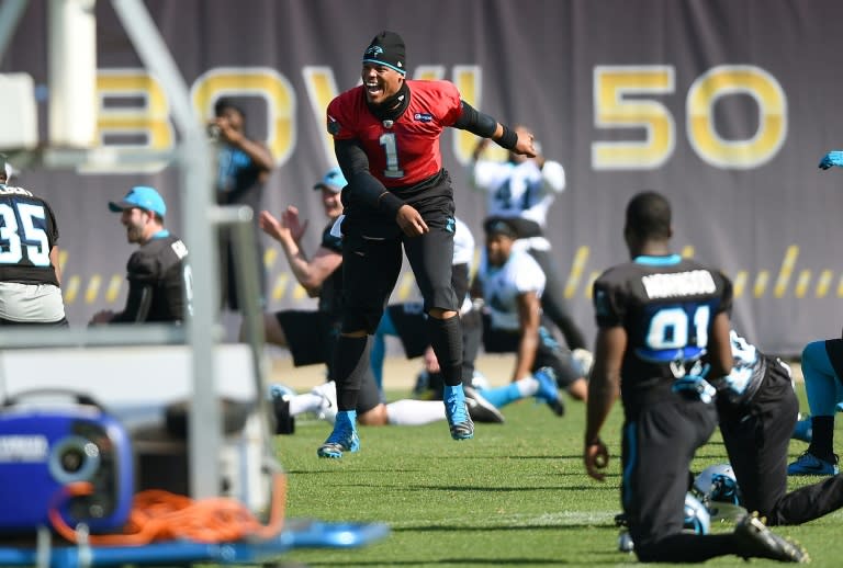Quarterback Cam Newton of the Carolina Panthers dances to music while his teammates stretch during practice at San Jose State University