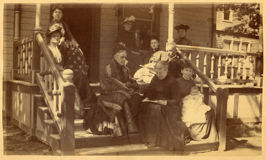 An 1894 photo shows Dr. Amanda Sanford Hickey (third from left), Dr. Eliza Mosher (center, to left of infant) and members of the Hickey family sitting together on a porch. (Courtesy University of Michigan Bentley Historical Library)