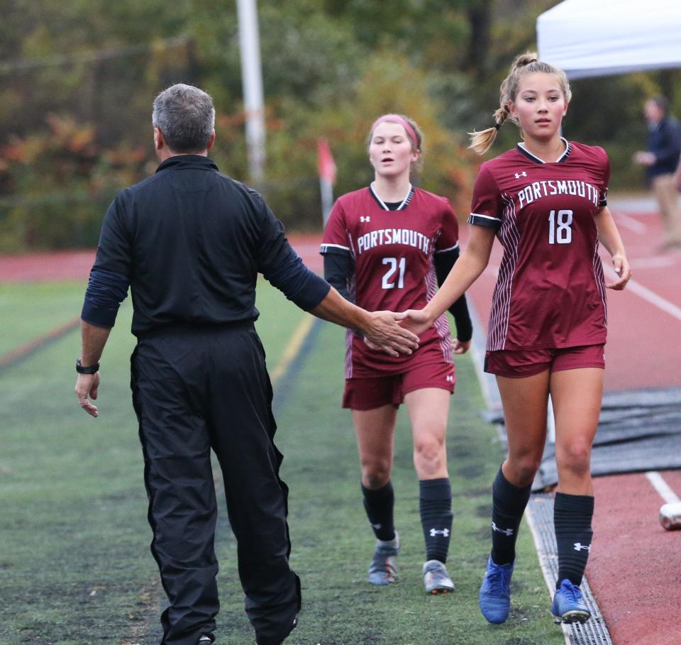 Portsmouth's Morgan Ruhnke gets a high-five from her coach Mickey Smith during Wednesday's Division I girls soccer quarterfinal.