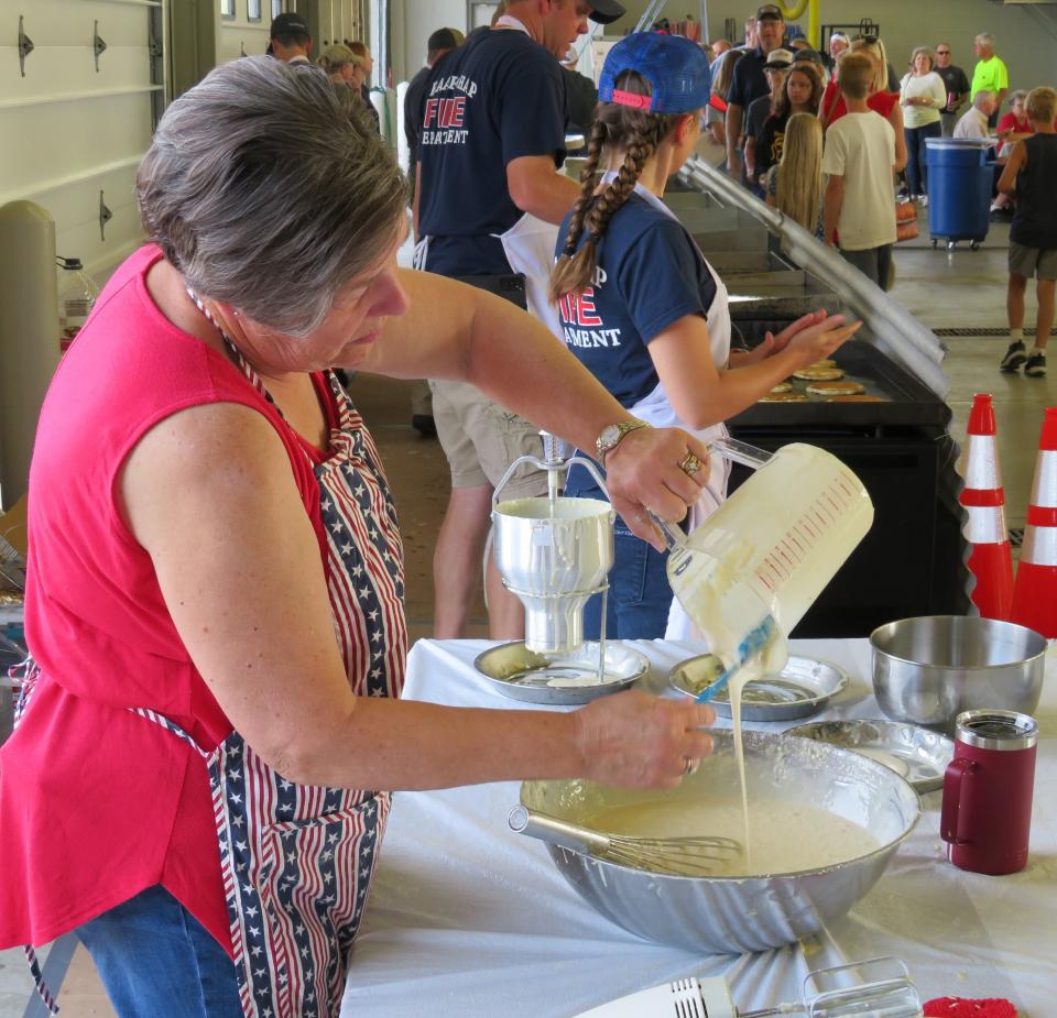 Members and family members of the Graafschap Fire Department serve up breakfast to hundreds of people on Monday, July 4, at the annual pancake breakfast at the fire station, 4534 60th St., Holland.