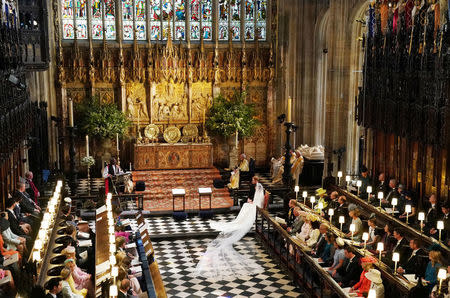 Prince Harry and Meghan Markle listen to an address by the Most Rev Bishop Michael Curry, primate of the Episcopal Church, in St George's Chapel at Windsor Castle during their wedding service in Windsor, Britain, May 19, 2018. Owen Humphreys/Pool via REUTERS