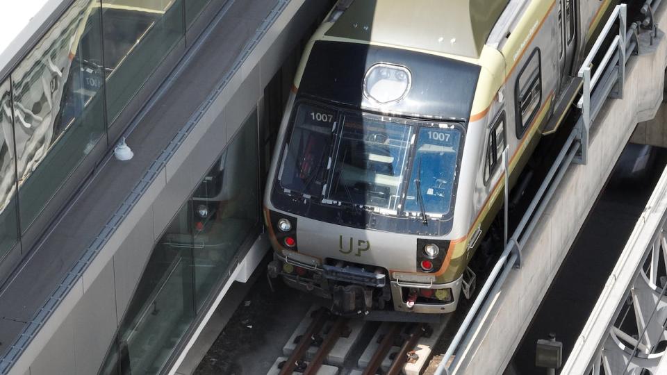 A drone image of an UP Express train at Toronto's Pearson International Airport. Opposition parties at Queen's Park questioned the Ford government on Wedneday over a policy reversal involving UP Express service on Tuesday. Planned changes to UP Express trains are now off the table.  (Yan Theoret/CBC - image credit)