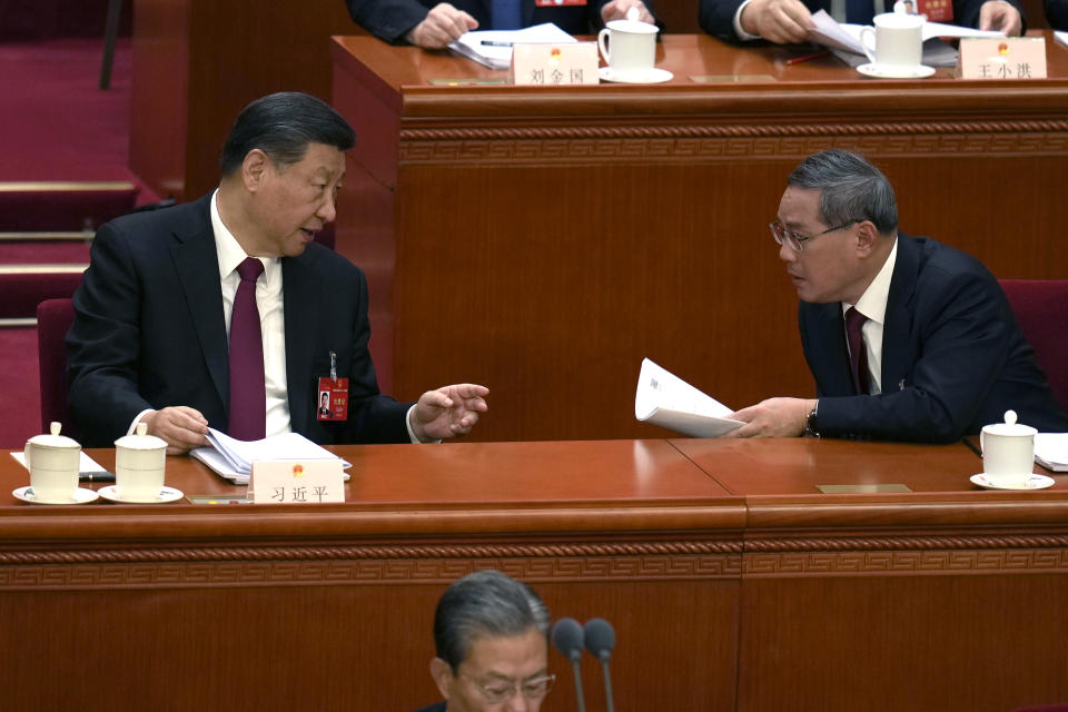 Chinese President Xi Jinping, left, gestures to Chinese Premier Li Qiang during the opening session of the National People's Congress (NPC) at the Great Hall of the People in Beijing, China, Tuesday, March 5, 2024. This year, breaking with three decades of tradition, officials said they would no longer be hosting the premier's press conference, removing a once-a-year opportunity for journalists to ask questions of a top Chinese leader. (AP Photo/Ng Han Guan)
