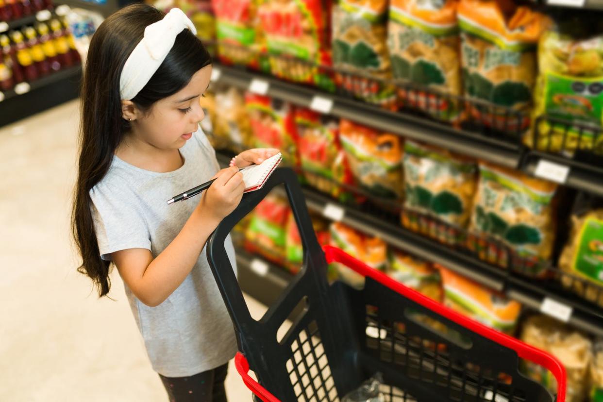 <span class="caption">Los niños pueden ayudar a hacer listas de mercado y confirmar que los padres han comprado todo lo que está en la lista.</span> <span class="attribution"><a class="link " href="https://www.gettyimages.com/detail/photo/helping-my-mom-to-do-grocery-shopping-royalty-free-image/1322934880" rel="nofollow noopener" target="_blank" data-ylk="slk:Antonio Diaz/iStock/Getty Images Plus;elm:context_link;itc:0;sec:content-canvas">Antonio Diaz/iStock/Getty Images Plus</a></span>