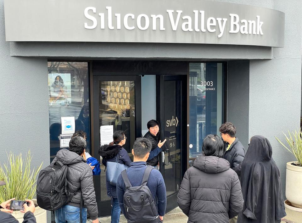 A worker announces on Friday that the Silicon Valley Bank (SVB) headquarters is closed in Santa Clara, California. SVB was shut down by California regulators and put in control of the U.S. Federal Deposit Insurance Corporation.