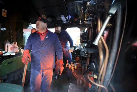 Men work in the engine room of the Flying Scotsman steam engine as it prepares to leave Kings Cross station in London, February 25, 2016. REUTERS/Paul Hackett