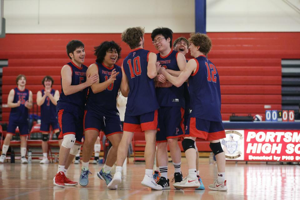 Portsmouth High players react after the Patriots earned a point during the school's history-making, first-ever varsity boys volleyball game on Monday.