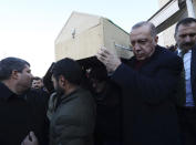 Turkey's President Recep Tayyip Erdogan carries a coffin of a victim after an earthquake hit Elazig, eastern Turkey, Friday, during the funeral procession for Salih Civelek and Aysegul Civelek, Saturday, Jan. 25, 2020. Rescue workers were continuing to search for people buried under the rubble of apartment blocks in Elazig and neighbouring Malatya. Mosques, schools, sports halls and student dormitories were opened for hundreds who left their homes after the quake (Presidential Press Service via AP, Pool)