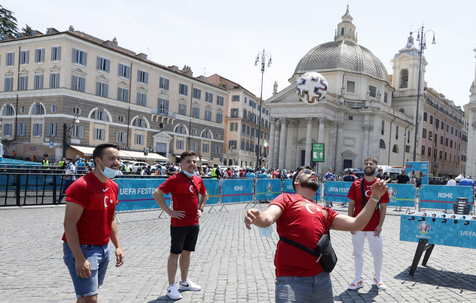 Turkish supporters play with a soccer ball in Rome's Piazza del Popolo hours before the start of the Euro 2020 soccer championship group A match between Italy and Turkey, at the Rome Olympic stadium Friday, June 11, 2021. Postponed by a year, the biggest sports event since the coronavirus brought the world to a halt kicks off Friday at Rome’s Stadio Olimpico, a milestone both for Europe and global sports. (AP Photo/Riccardo De Luca)