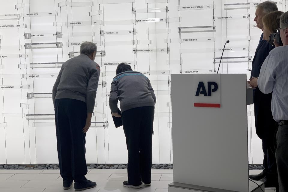 Children of former Associated Press journalist Y.C. Jao, Rao Jian, left, and his younger sister Rao Jiping, right, bow after unveiling their father's name, which was added to the memorial Wall of Honor dedicated to fallen journalists of The Associated Press at the AP headquarters in New York on Wednesday, Dec. 11, 2019. At right are AP President and CEO Gary Pruitt, third from right, and AP Executive Editor Sally Buzbee, second from right. Jao was executed in April 1951, when Chinese authorities accused him of spying and of counterrevolutionary activities, all owing to his work for AP. (AP Photo/Wong Maye-E)