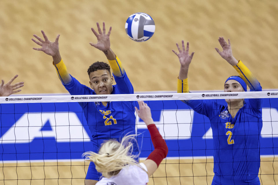 Pittsburgh's Serena Gray (21) and Valeria Vazquez Gomez (2) try to block Louisville's Anna DeBeer (14) in the second set in the semifinals of the NCAA volleyball tournament, Thursday, Dec. 15, 2022 in Omaha, Neb. (AP Photo/John S. Peterson)
