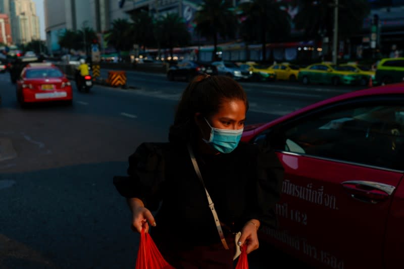 A woman wears a protective face mask due to the coronavirus disease (COVID-19) outbreak, as she shops in central Bangkok