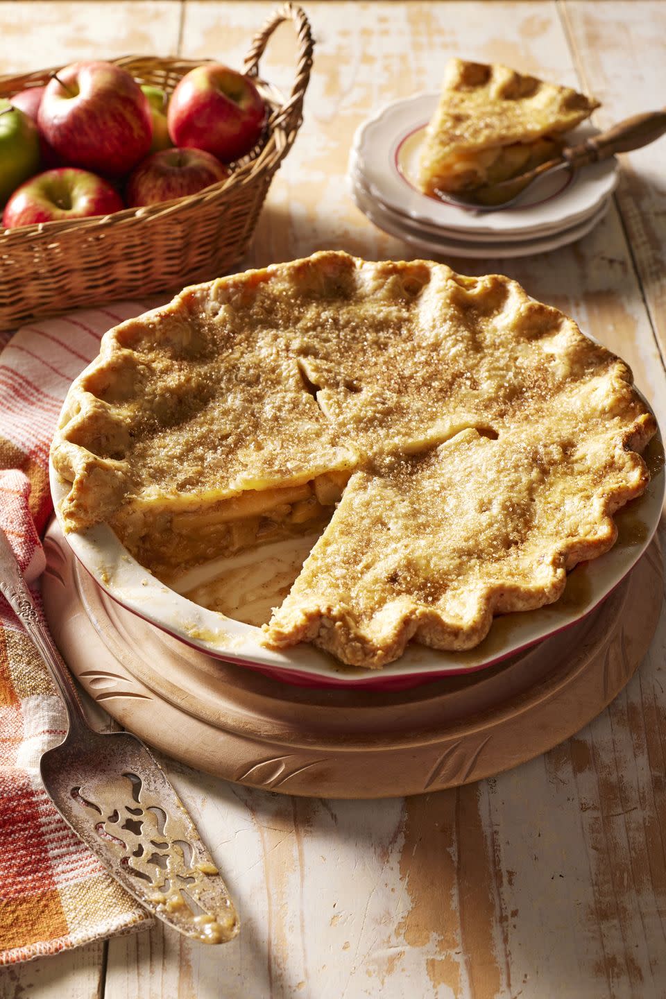 double crust brown butter apple pie in a red pie dish with a slice removed to show the inside
