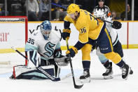 Seattle Kraken goaltender Joey Daccord (35) gloves a shot as Nashville Predators left wing Cole Smith (36) skates in during the second period of an NHL hockey game Thursday, March 23, 2023, in Nashville, Tenn. (AP Photo/Mark Zaleski)