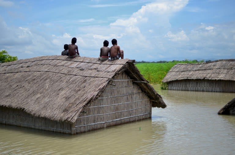 <p>Indian children sit on the roof of a home submerged in flood waters in Batahidia on the Brahmaputra River in South Kamrup, southwest of Guwahati, on July 27, 2016. </p>