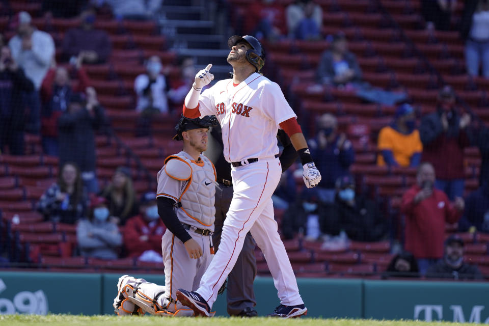 Boston Red Sox's J.D. Martinez, right, celebrates as he scores on a home run as Baltimore Orioles' Chance Sisco, left, looks on during the fourth inning of a baseball game, Sunday, April 4, 2021, in Boston. (AP Photo/Steven Senne)