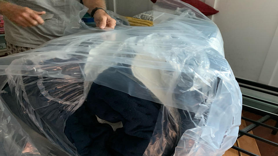 The DreamCloud Mattress wrapped in plastic on a bed frame