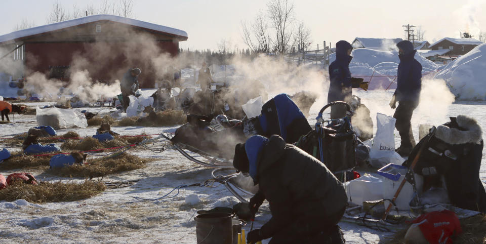 Mushers handle their dog care on a cold morning in the McGrath, Alaska, checkpoint during the Iditarod Trail Sled Dog Race on Saturday, March 13, 2021. (Zachariah Hughes/Anchorage Daily News via AP, Pool)