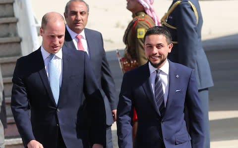 Prince William (L) is greeted at Amman's Marka military airport by Jordanian Crown Prince Hussein bin Abdullah on June 24, 2018 - Credit:  KHALIL MAZRAAWI