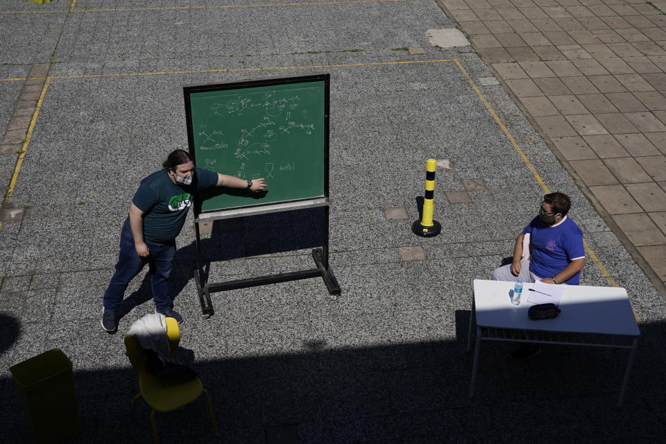 FILE - In this Oct. 13, 2020 file photo, a teacher leads a lesson outdoors at the school Hipólito Yrigoyen in Buenos Aires, Argentina, on the first day since the COVID-19 pandemic outbreak that in-person classes in the capital for students in their last year of primary and secondary school were restarted, but outdoors. Argentina reached 1 million confirmed coronavirus cases on Monday, Oct. 19, 2020, according to the Ministry of Health. (AP Photo/Victor R. Caivano, File)