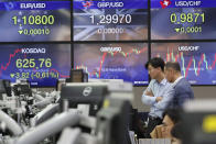 Currency traders watch monitors at the foreign exchange dealing room of the KEB Hana Bank headquarters in Seoul, South Korea, Wednesday, Dec. 4, 2019. Asian stock markets followed Wall Street lower after President Donald Trump cast doubt over the potential for a trade deal with China this year. (AP Photo/Ahn Young-joon)
