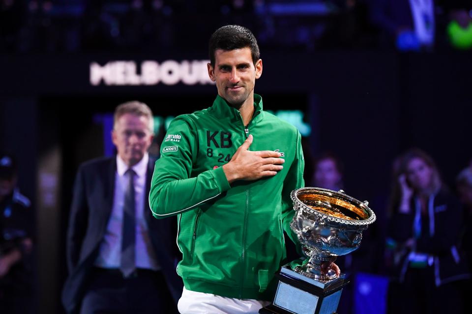 Serbia's Novak Djokovic smiles and thanks the crowd with the Norman Brooks Challenge Cup trophy.