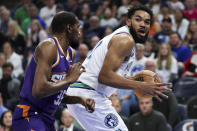 Minnesota Timberwolves center Karl-Anthony Towns, right, works toward the basket as Phoenix Suns forward Kevin Durant defends during the first half of an NBA basketball game, Sunday, April 14, 2024, in Minneapolis. (AP Photo/Matt Krohn)