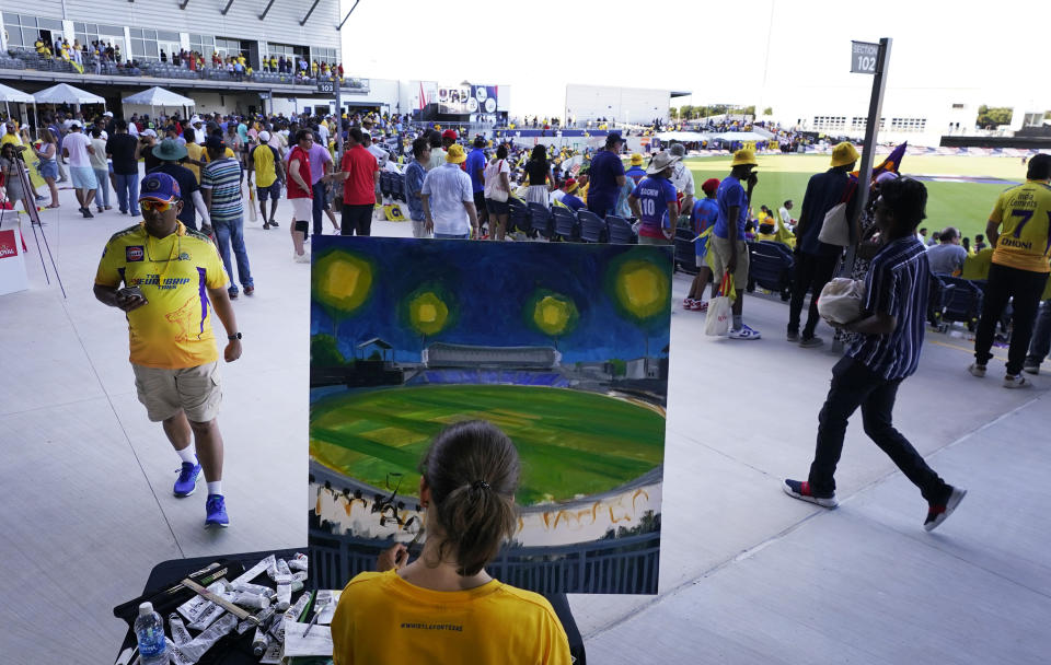 An artist paints the scene before the Texas Super Kings and Los Angeles Knight Riders compete in a Major League Cricket match in Grand Prairie, Texas, Thursday, July 13, 2023. (AP Photo/LM Otero)