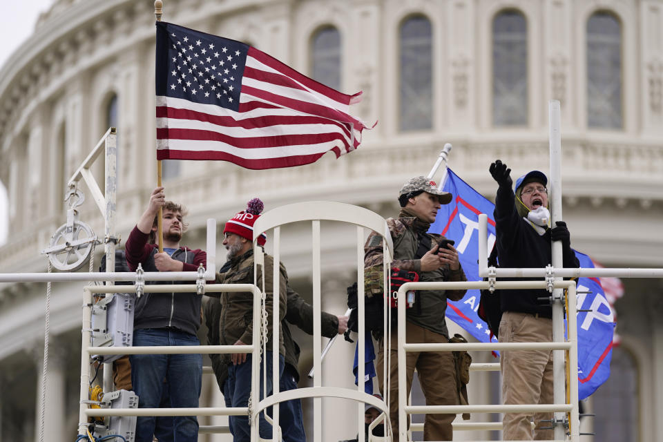 Rioters loyal to President Donald Trump yell and wave flags on the West Front of the U.S. Capitol on Jan. 6, 2021, in Washington. (AP Photo/Julio Cortez)