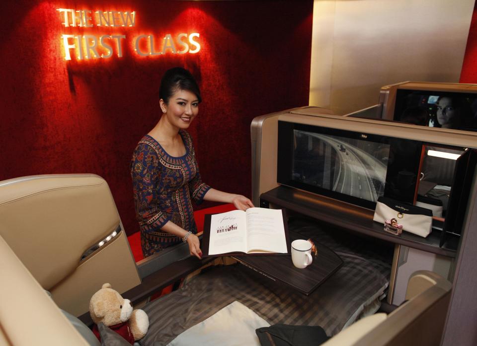 A Singapore Airlines Ltd stewardess poses at a first class cabin seat during the launch of their new generation of cabin products at Changi Airport in Singapore