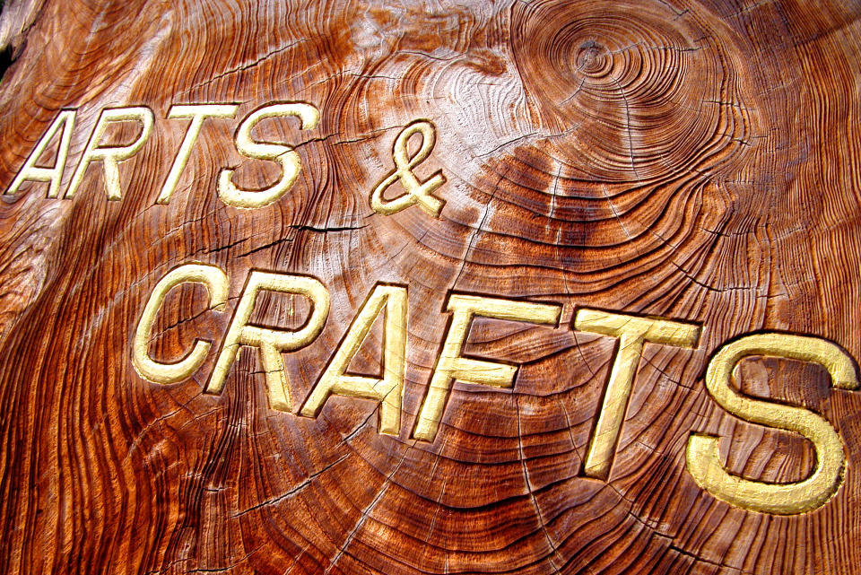 The words Arts and Crafts, carved into a roughly hewn slab of dark wood.