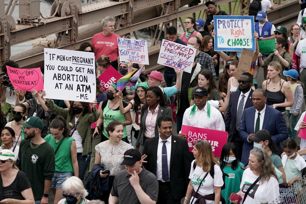 New York City Mayor Eric Adams, center, marches with protesters as they cross the Brooklyn Bridge during an abortion rights demonstration, Saturday, May 14, 2022, in New York. 