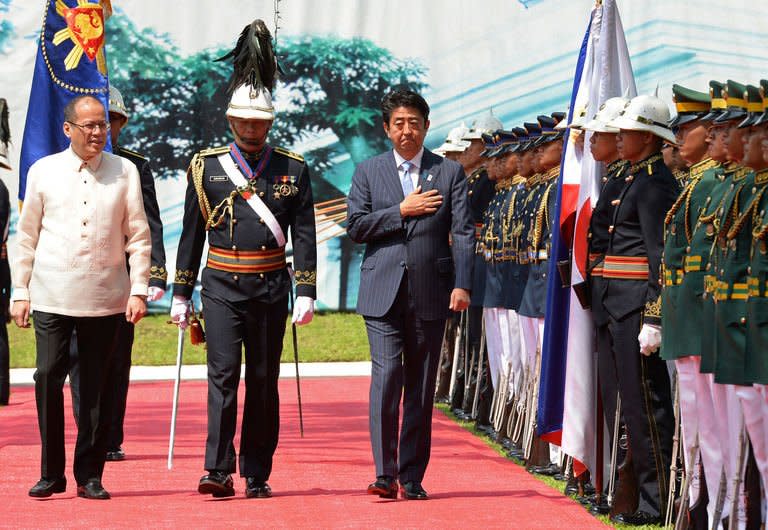 Japan's Prime Minister Shinzo Abe (C-R) and Philippine President Benigno Aquino (L) review an honour guard during Abe's welcoming ceremony at the Malacanang Palace in Manila, on July 27, 2103. Abe is in Manila for a two-day visit focusing on defence cooperation amid territorial disputes with China