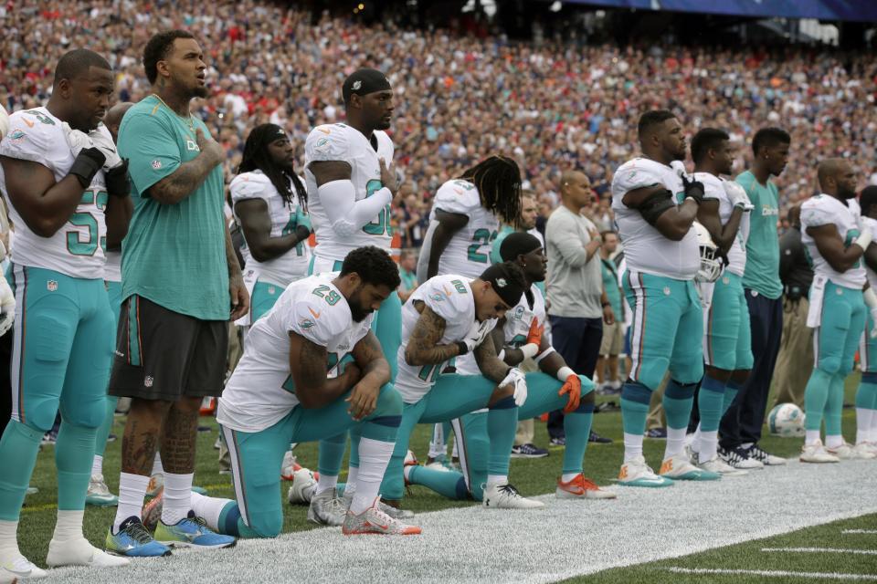 <p>Miami Dolphins Arian Foster (29), Kenny Stills (10) and Michael Thomas (31) kneel during the national anthem before an NFL football game against the New England Patriots Sunday, Sept. 18, 2016, in Foxborough, Mass. (AP Photo/Steven Senne) </p>