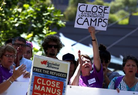 Protesters react as they hold placards and listen to speakers during a rally in support of refugees in central Sydney, Australia, October 19, 2015. REUTERS/David Gray/File photo