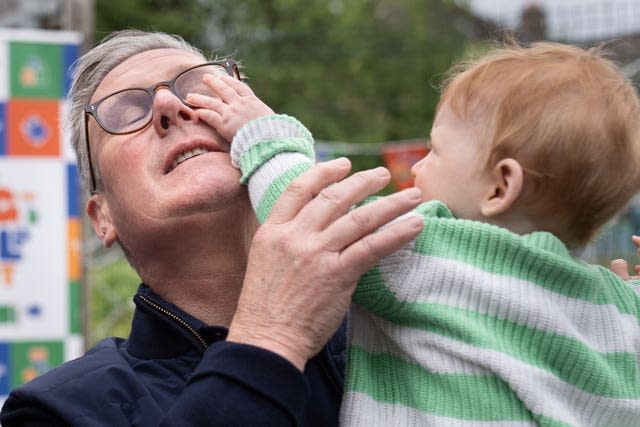  Labour leader Sir Keir Starmer holds a child