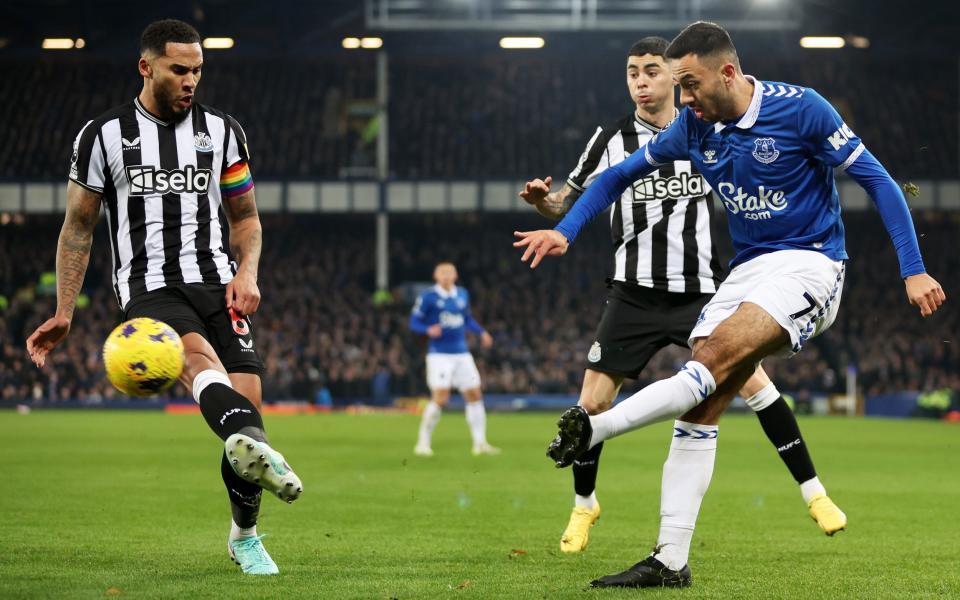 Dwight McNeil of Everton passes the ball whilst under pressure from Jamaal Lascelles of Newcastle United during the Premier League match between Everton FC and Newcastle United at Goodison Park on December 07, 2023 in Liverpool, England