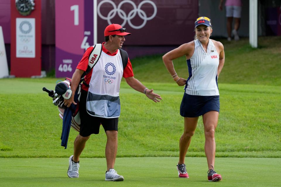 Lexi Thompson walks off the first tee box with her caddie during the first round of the women's individual stroke play at the Olympics.