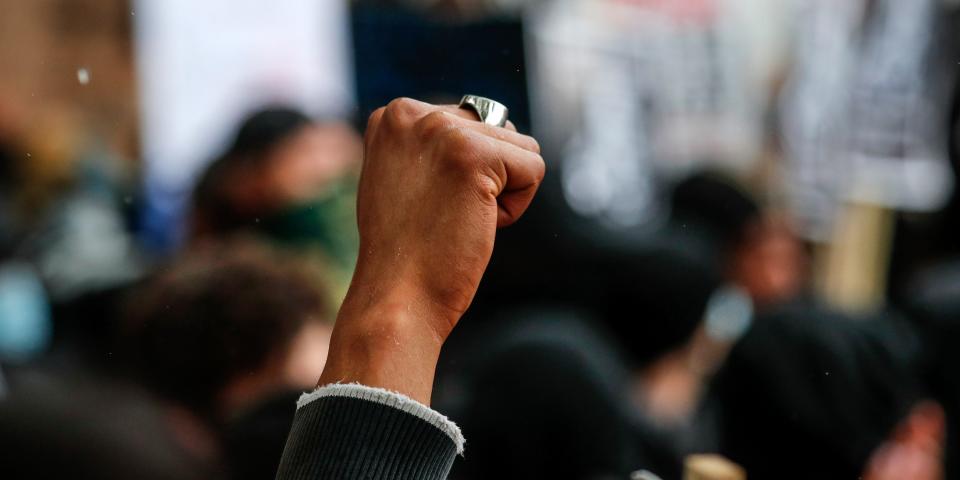 A woman clenches her fist during a Black Lives Matter rally in Parliament Square in London, Saturday, June 6, 2020, as people protest against the killing of George Floyd by police officers in Minneapolis, USA. Floyd, a black man, died after he was restrained by Minneapolis police while in custody on May 25 in Minnesota. (AP Photo/Frank Augstein)