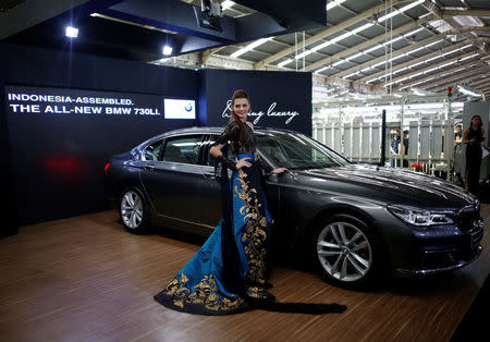 A model poses next to a BMW 7 Series car assembled locally during a media launch at a Gaya Motor assembly plant in Jakarta, Indonesia November 30, 2016. REUTERS/Darren Whiteside