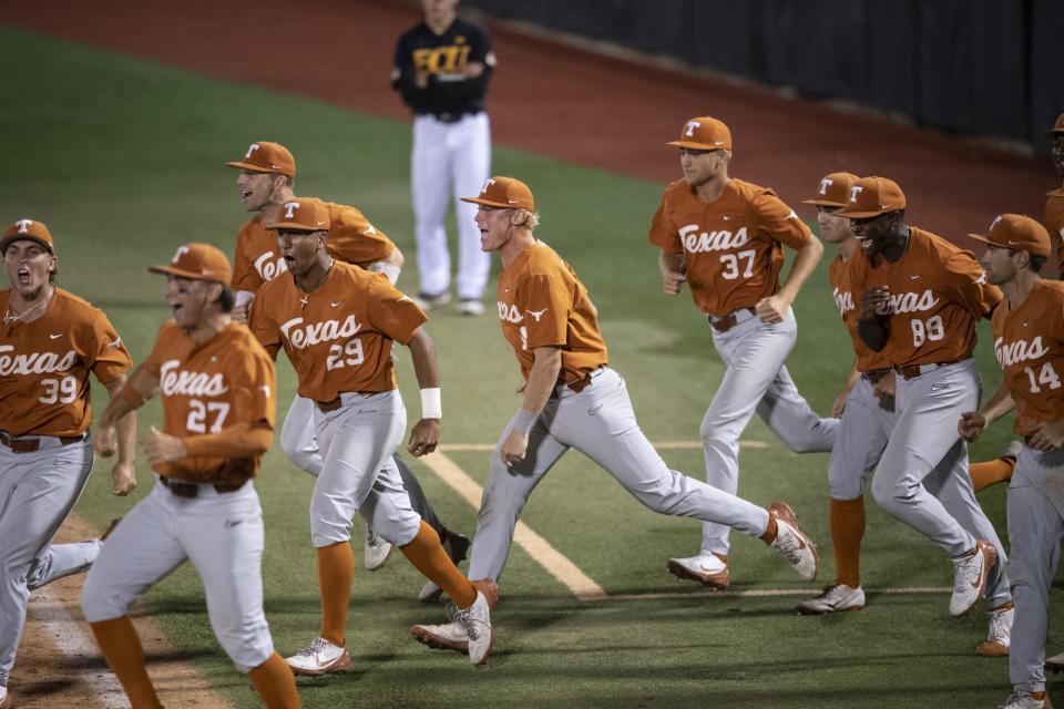 Texas players rush onto the field in the wee hours Monday after their 11-1 win over East Carolina in the deciding third game of the Greenville Super Regional. The Longhorns will make their record 38th trip to the College World Series later this week.